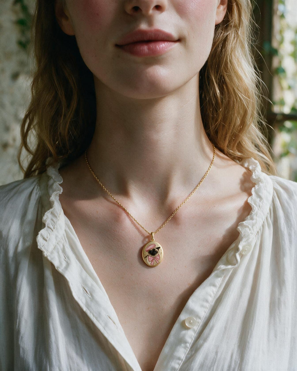 An enamel pendant of a hand-painted Siamese
