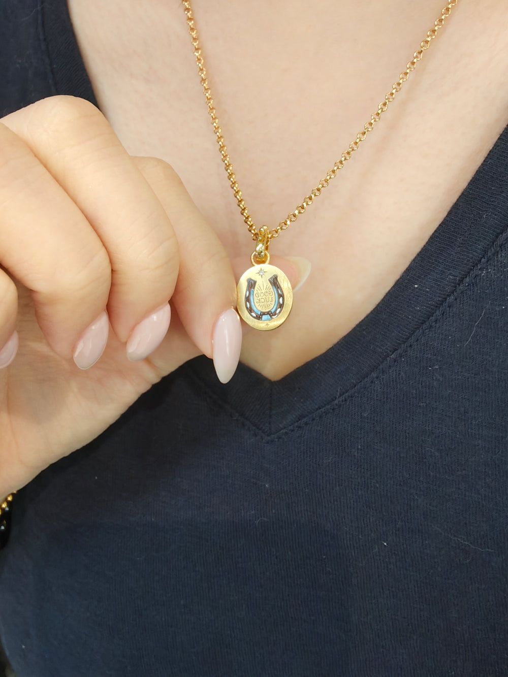 An enamel portrait pendant of a small horseshoe