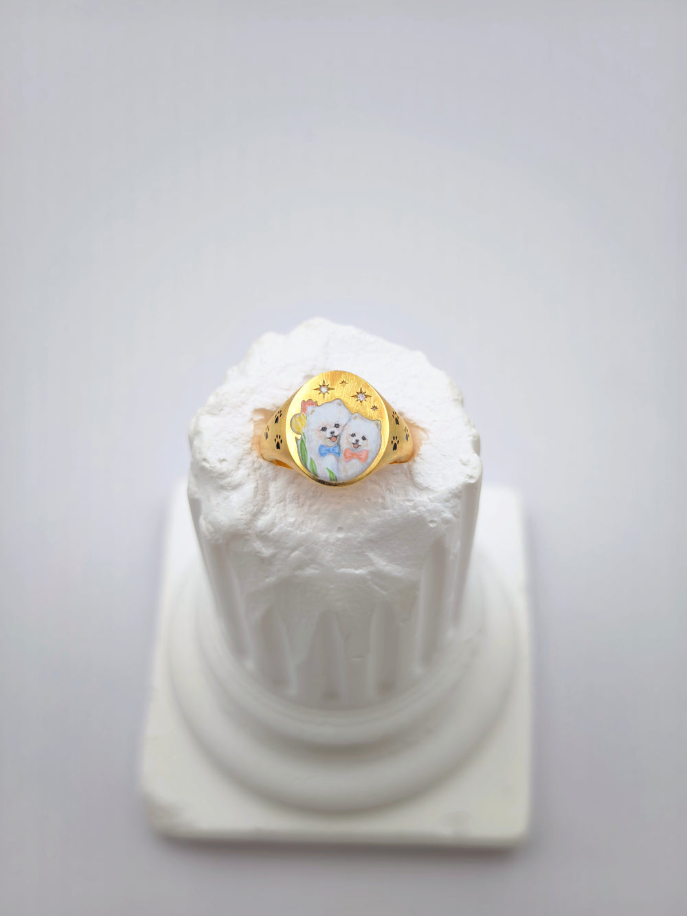An enamel pendant with a single hand-painted word in script